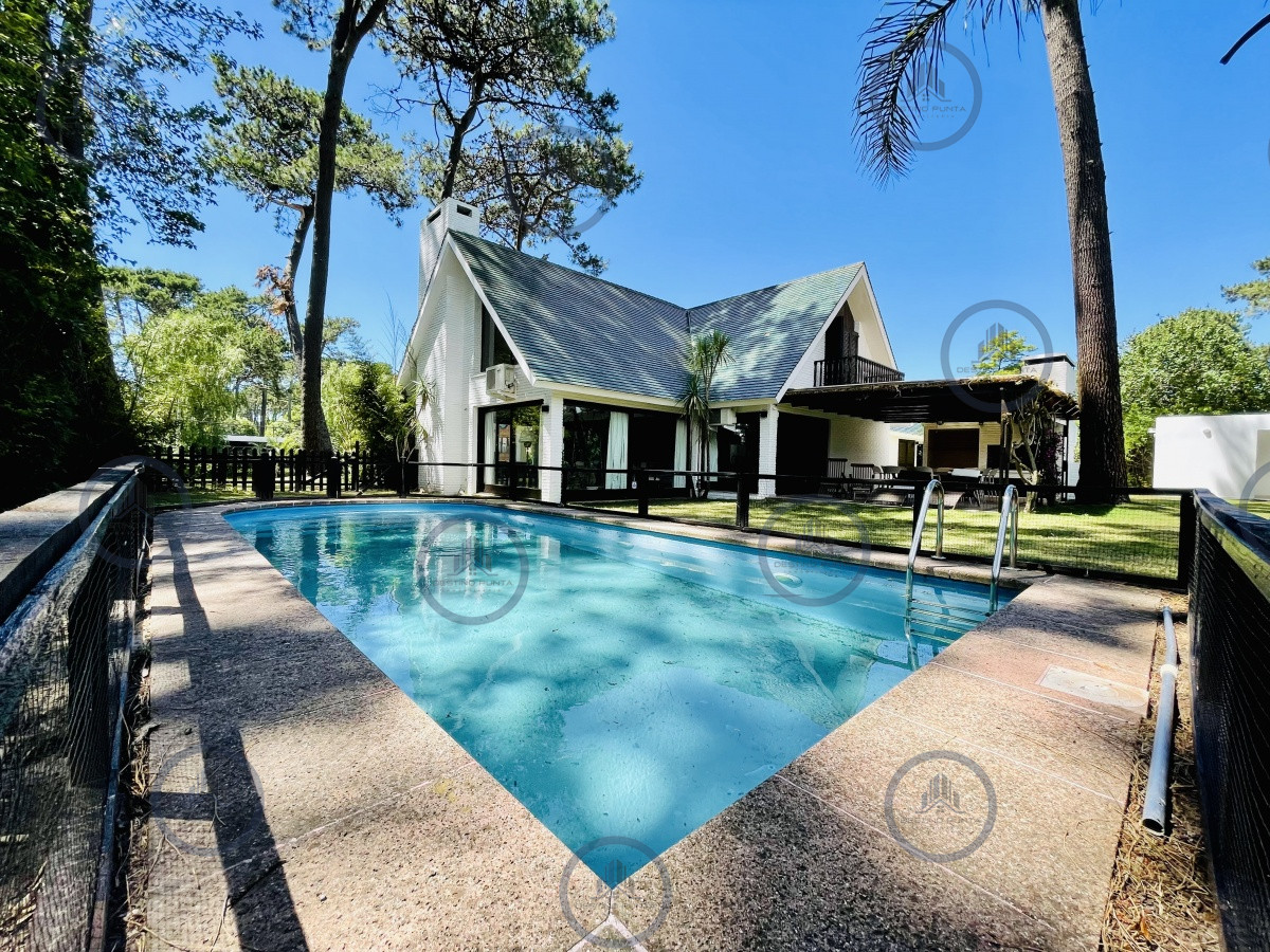 Sólida y amplia casa de cinco dormitorios más dependencia de servicio y piscina, Lugano, Punta del Este — fotografía 1