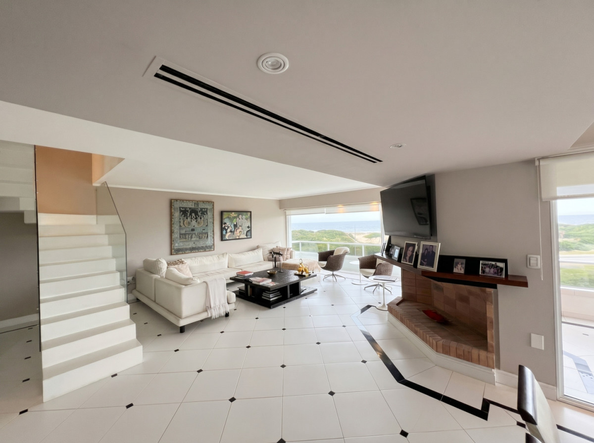 Penthouse duplex sobre Playa Brava, Punta del Este, con vista de 360 grados al mar, las dunas y la ciudad. Una propiedad exclusiva, de las que casi no aparecen en el mercado, pensada para vivir mirando el horizonte desde cualquier ambiente.

Son 720 m² distribuidos en dos niveles: 273 m² propios y el resto en terrazas que envuelven ambos pisos del duplex. La unidad cuenta con cuatro dormitorios, los cuatro en suite, con la suite principal resuelta en doble baño y vestidor, y siete baños en total más toilette. Living y comedor integrados con ventanales de piso a techo orientados al mar, y cocina de diseño con isla central y equipamiento profesional. Suma playroom, parrillero, dependencia y baño de servicio, lavadero, estufa a leña y calefacción por losa radiante sectorizada en toda la unidad.

Amenities del edificio:
Piscina, sauna y gimnasio. Servicio de mucamas. Ubicación de primera línea sobre Playa Brava, a pasos del mar y a minutos del centro de Punta del Este, cerca de restaurantes y comercios.

Un activo único por metraje, vista y ubicación, para quienes buscan exclusividad y la mejor calidad de vida en Punta del Este.

Precio de venta: USD 2.880.000

Características:


Barrio: Playa Brava
Vista: 360 grados
Superficie total: 720 m² · Superficie propia: 273 m² (resto: terrazas en ambos niveles)
Dormitorios: 4 (en suite) · Baños: 7 + toilette
Suite principal con doble baño y vestidor
Cocina definida · Living · Comedor · Comedor diario · Lavadero · Playroom
Dependencia y baño de servicio · Servicio de mucamas
Estufa a leña · Calefacción: losa radiante sectorizada
Parrillero · Piscina · Sauna · Gimnasio