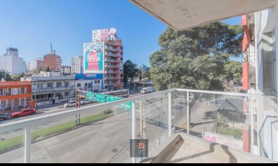 Edificio de viviendas de 1 y 2 dormitorios con patio verde.